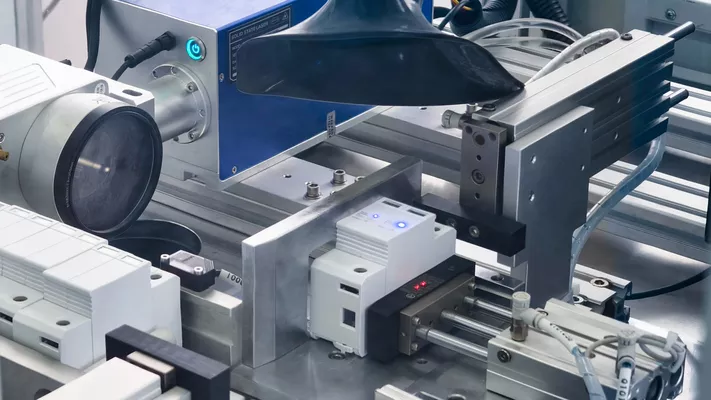 Automated laser printing machine engraving custom branding and specifications onto OEM surge protection devices at Thor manufacturing facility