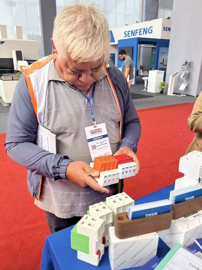 Visitor handling Thor pluggable SPD modules at booth E43 during Expo Peru Industrial 2026